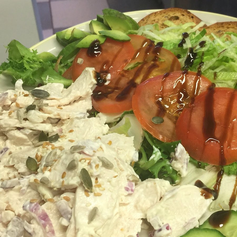 A close-up of a chicken salad plate with tomato and cucumber at Nico's