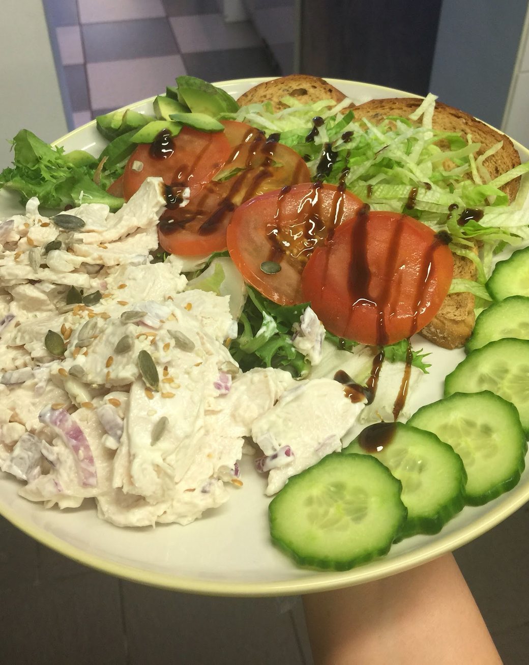 A chicken salad plate with tomato, cucumber and avocado at Nico's